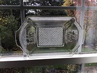 Full view of pressed glass bread tray showing overall shape, patterned center and deer motifs