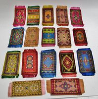 Group of 17 rug-pattern silks arranged in rows showing variety of colours and patterns
