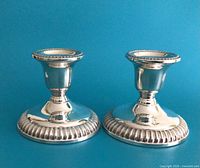 Front view of both sterling silver candlesticks