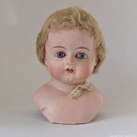 Front view of composition doll head showing facial features and wig