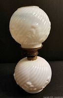 Full view of miniature milk glass lamp, globe atop font