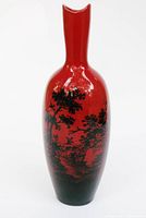 Front view of Royal Doulton Flambe Woodcut bud vase showing red glaze and black woodland scene