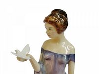 Upper view of figurine showing face, hair, bird in hand
