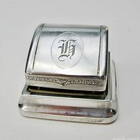 Front view showing monogrammed curved lid and base