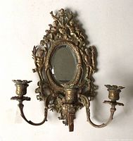 Full view of brass sconce showing mirror, three candle arms, cherub decorations