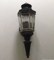 Full view of iron coach light mounted on wall