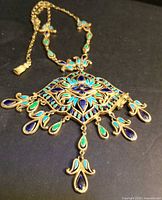 Full view of necklace showing pendant, chain and tassel