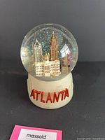 Front view of snow globe showing ATLANTA text and skyline inside globe
