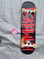 Full view of complete skateboard underside showing graphic, trucks, wheels
