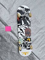 Full view of skateboard underside showing graphics, trucks, wheels