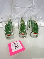 Six clear tumbler glasses with Christmas tree design front view