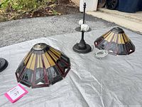 Pair of stained glass shades with hardware on tarp