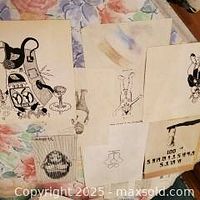 Group shot of seven artworks spread on floral surface