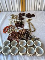 Overview of all necklaces and napkin rings displayed on white cloth