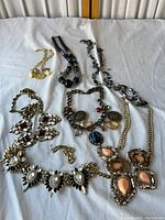 All seven jewellery pieces laid out on white cloth