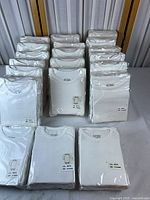 Front view of all sealed white baby bodysuits arranged in rows