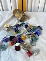 Group shot of petrified wood and assorted stones and glass on cloth