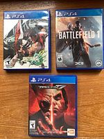 Front view of three PS4 game cases: Guilty Gear Xrd REV 2, Battlefield 1, Tekken 7