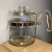 Side view of Pyrex glass percolator showing lid, handle, stainless band and glass body