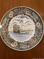 Front of plate showing Mayflower scene and floral border