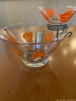 Large clear glass chip bowl, small dip bowl with orange accents in wire rack