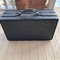 Closed black Hartmann suitcase upright showing monogram