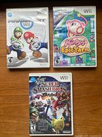 Front view of three Wii game cases: Mario Kart Wii, Kirby’s Epic Yarn, Super Smash Bros. Brawl