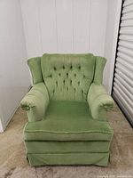 Front view of green tufted armchair