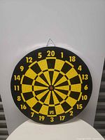 Front view of the 17" black and yellow cork dartboard showing full numbered face and hanging loop