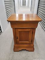 Front view of Hooker wooden nightstand showing drawer and cupboard door