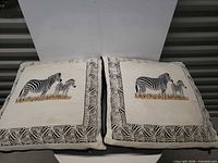Both zebra pillows front view showing embroidery and borders
