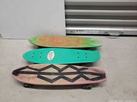 Three penny boards stacked showing deck surfaces