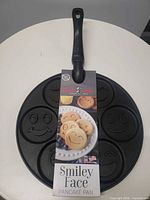 Full view of Nordic Ware Smiley Face pancake pan with packaging