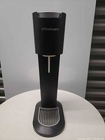 Front view of black SodaStream water maker on table