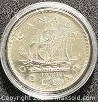 Reverse of 1949 Canadian silver dollar showing sailing ship and CANADA DOLLAR 1949 legend in plastic capsule