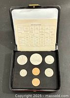 Open presentation case showing seven coins and specification card
