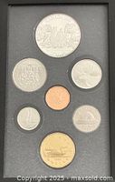 Reverse side of seven coins in display case