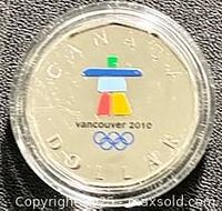 Reverse of colourized 2010 Inukshuk loonie in capsule