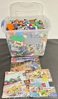 Full view of tub filled with Lego pieces and manuals laid in front