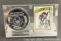Front view of acrylic case showing autographed card and puck