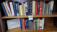 Two shelves containing approximately forty vintage books in assorted sizes and colors