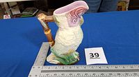 Full view of parrot pitcher with ruler for scale