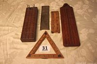 Five cribbage boards laid out showing size, shape and materials