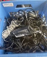 Crate filled with assorted laptop chargers and cords