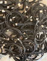 Pile of multiple identical black HDMI cables showing connectors