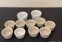 Group of 12 ceramic ramekins displayed on table