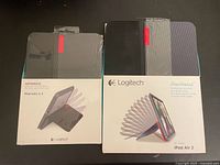 Front view of both sealed Logitech AnyAngle cases in boxes