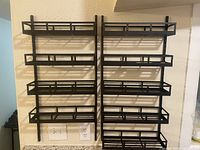 Front view of two identical black metal spice racks mounted on wall