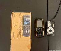 Sonim phone box, phone, and Kodak camera displayed together