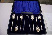 Set of six apostle spoons and tongs in blue satin-lined case